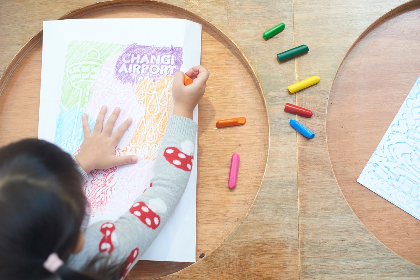 A child colouring a drawing with crayons